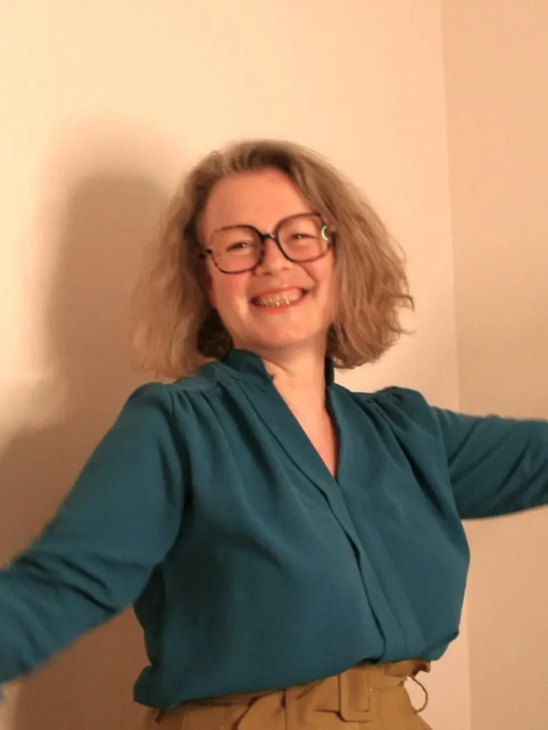 Laure Martin, psychopraticienne à Bordeaux, sourit à pleines dents, les bras ouverts !