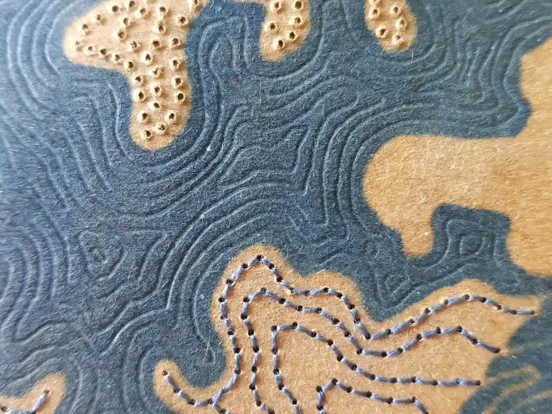 Visuel du coaching SPIRALE, un coaching pour donner du sens à ta vie : vue sur une œuvre d'art bleu et marron avec des lignes qui ressemblent à des courbes de niveau.
